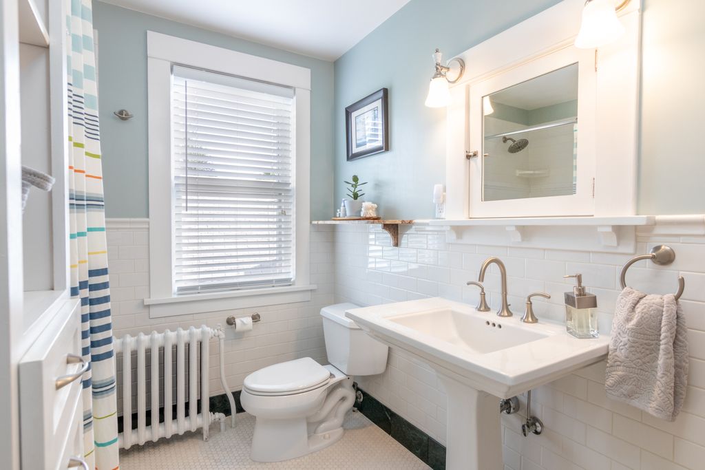 A clean and modern bathroom with white fixtures and natural lighting.